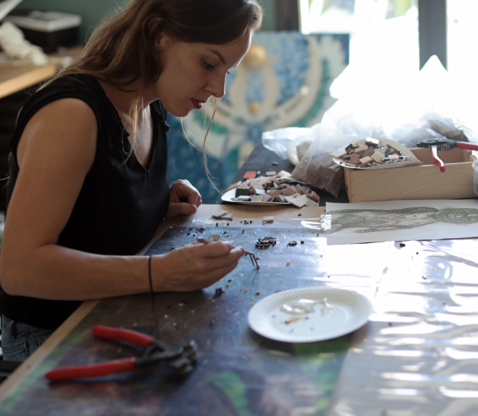 Sidonie, artiste mosaïste, en train de créer un tableau en mosaïque dans son atelier à Orléans