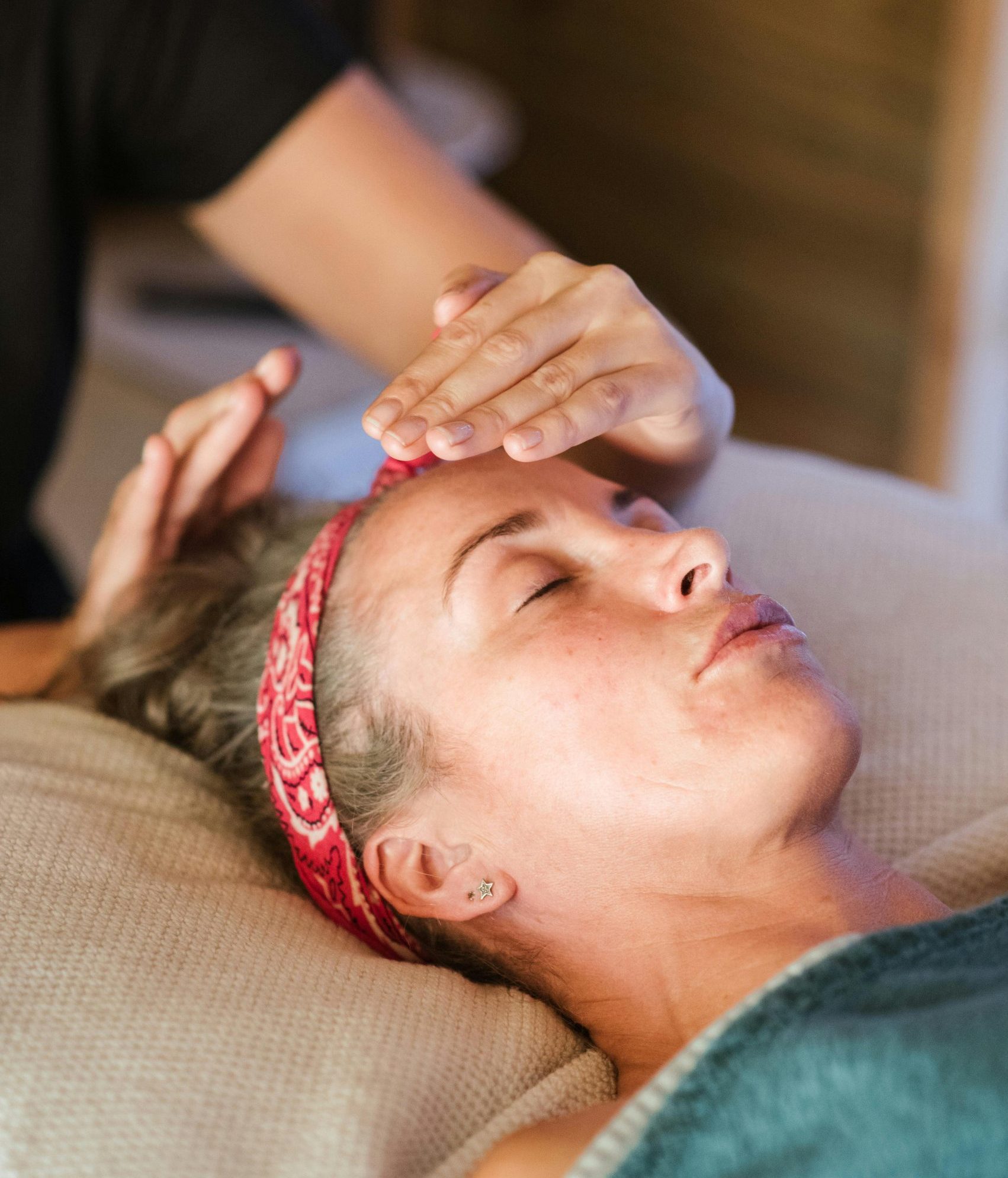 Mains posées sur une personne pendant un soin – illustration d’une séance de Reiki en cours